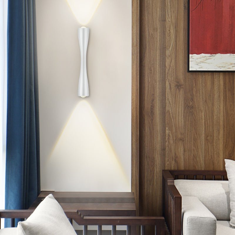 White slim wall light lit on a wood panelled wall beside blue curtains