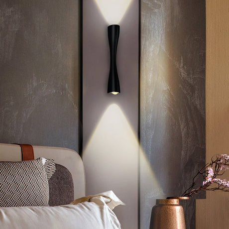 Black slim wall light throwing beams up and down a textured bedroom wall