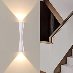White slim wall light lit beside a staircase with beams above and below