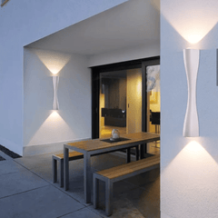 Gold slim wall light on an outdoor wall beside a covered dining terrace