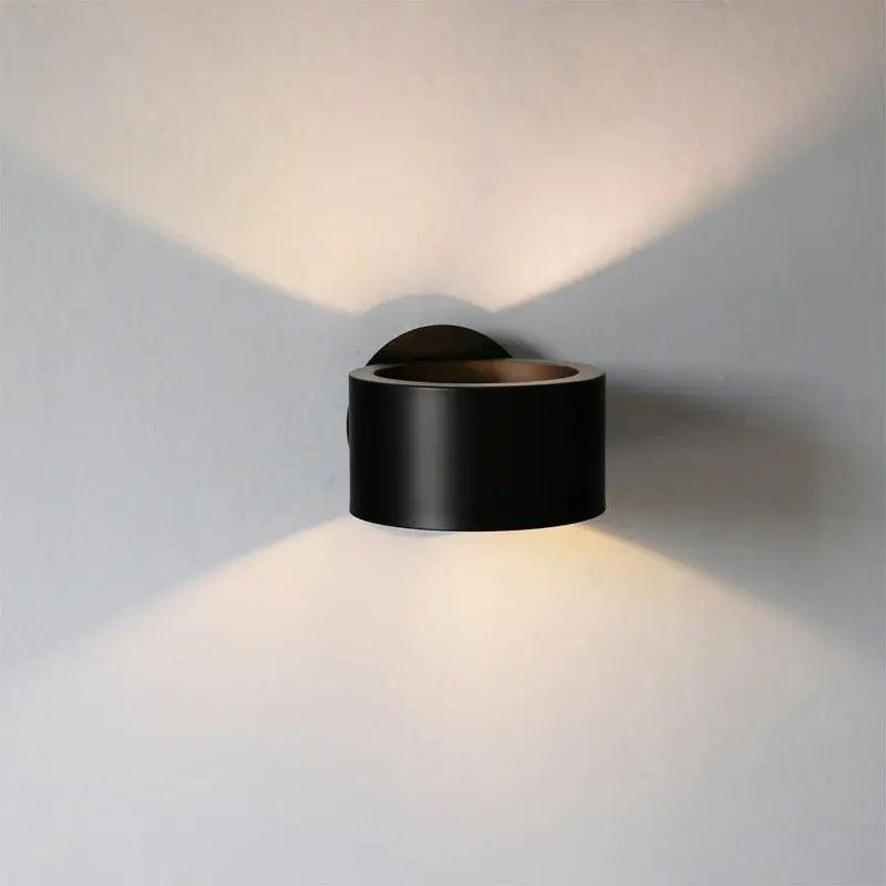 Black curled sconce casting a narrow beam up and down a white wall