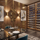 Two gold up and down sconces lit on a panelled dining room wall