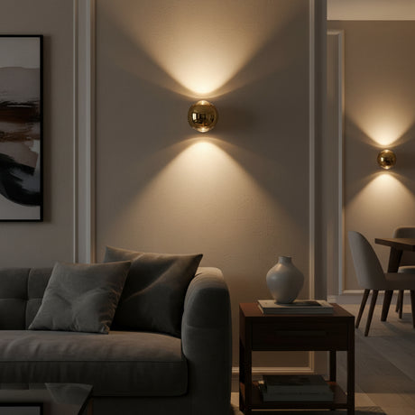 Gold orb wall sconce lit on a white wall with beams above and below