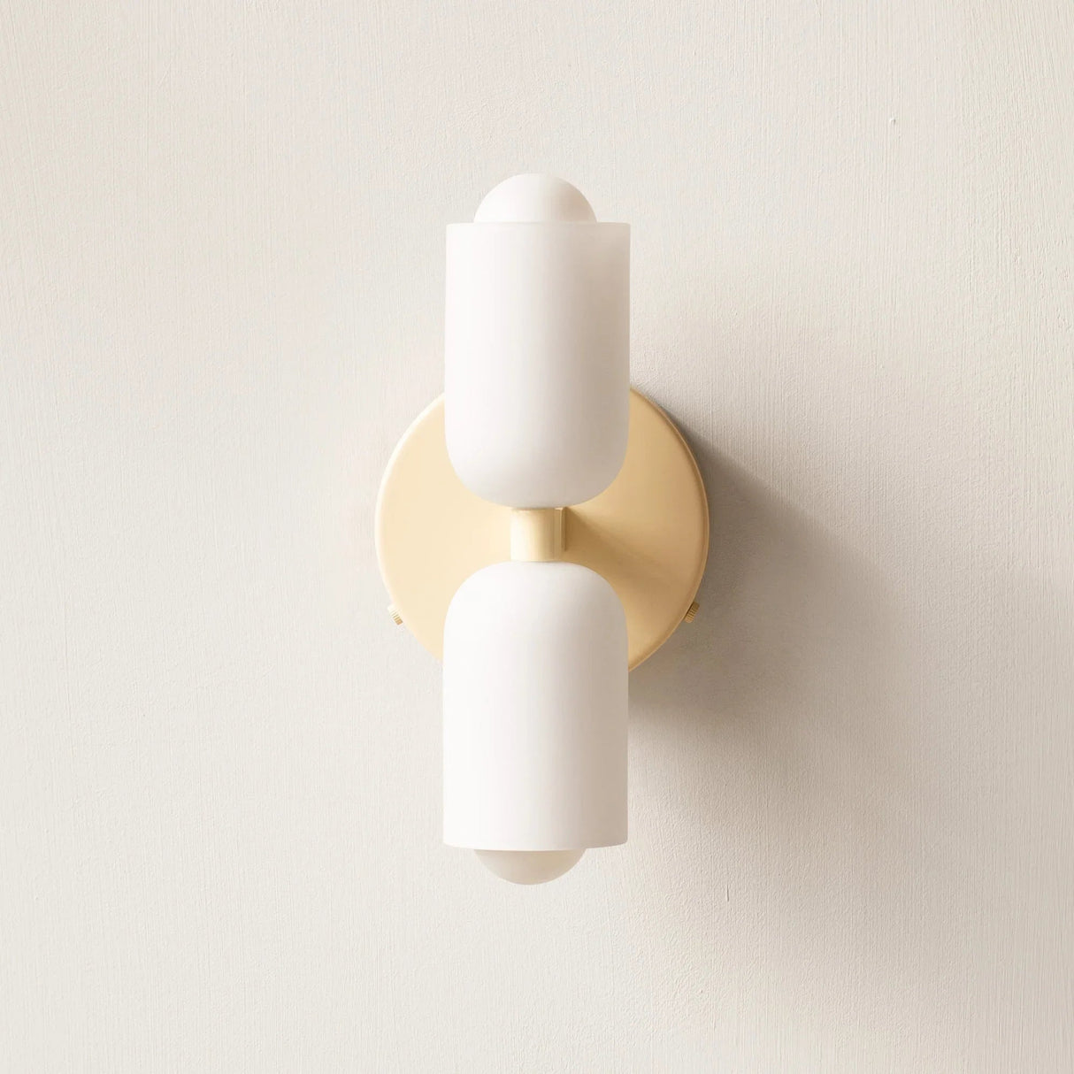 Detail view of the gold up and down wall light against a textured wall