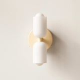 Detail view of the gold up and down wall light against a textured wall