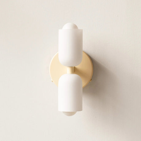 Detail view of the gold up and down wall light against a textured wall