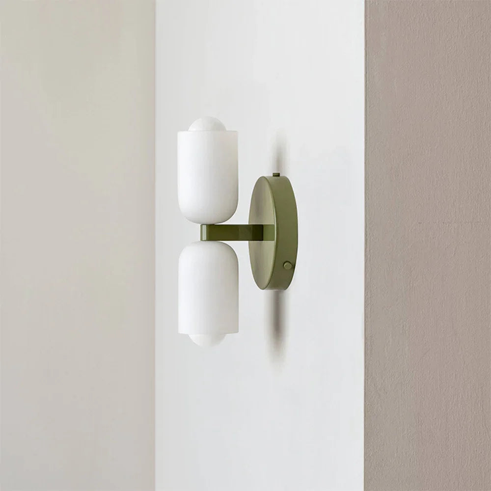 Up and down wall light with an olive green backplate and two white acrylic shades