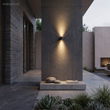 Dark up and down light throwing narrow beams on a concrete column at night