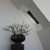 Textured black ceramic vase displayed on modern console table