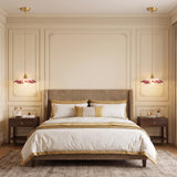 Pair of pink glass flower pendants hanging beside a bed as bedside lights