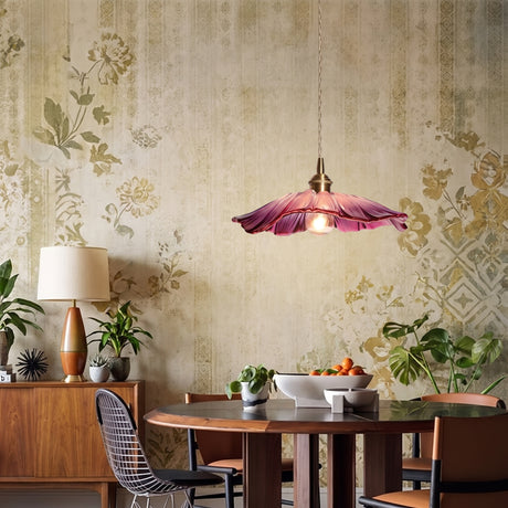 Pink ruffled glass flower pendant above a round dining table and floral wallpaper