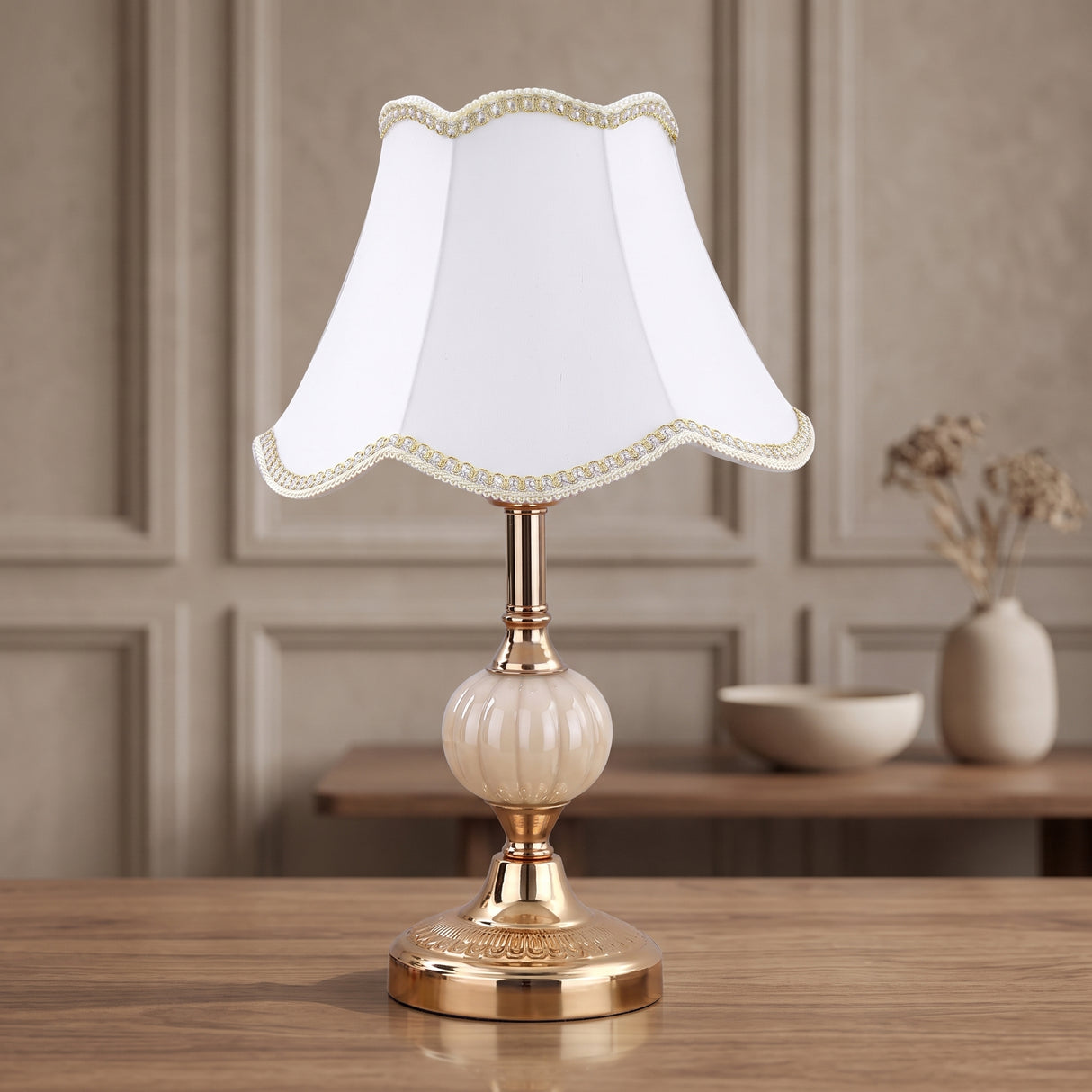 White bell fabric shade on a gold fluted glass base table lamp