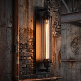 Black cage wall sconce with a tube filament bulb on a brick wall