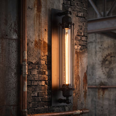 Black cage wall sconce with a tube filament bulb on a brick wall