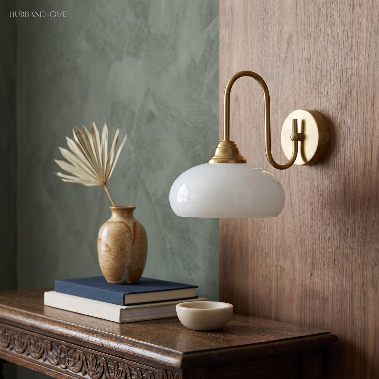 Copper milk glass wall sconce beside a green wall and console table