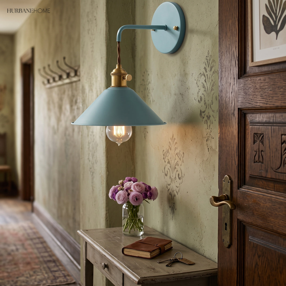 Blue cone shade sconce lit in a hallway above a side table