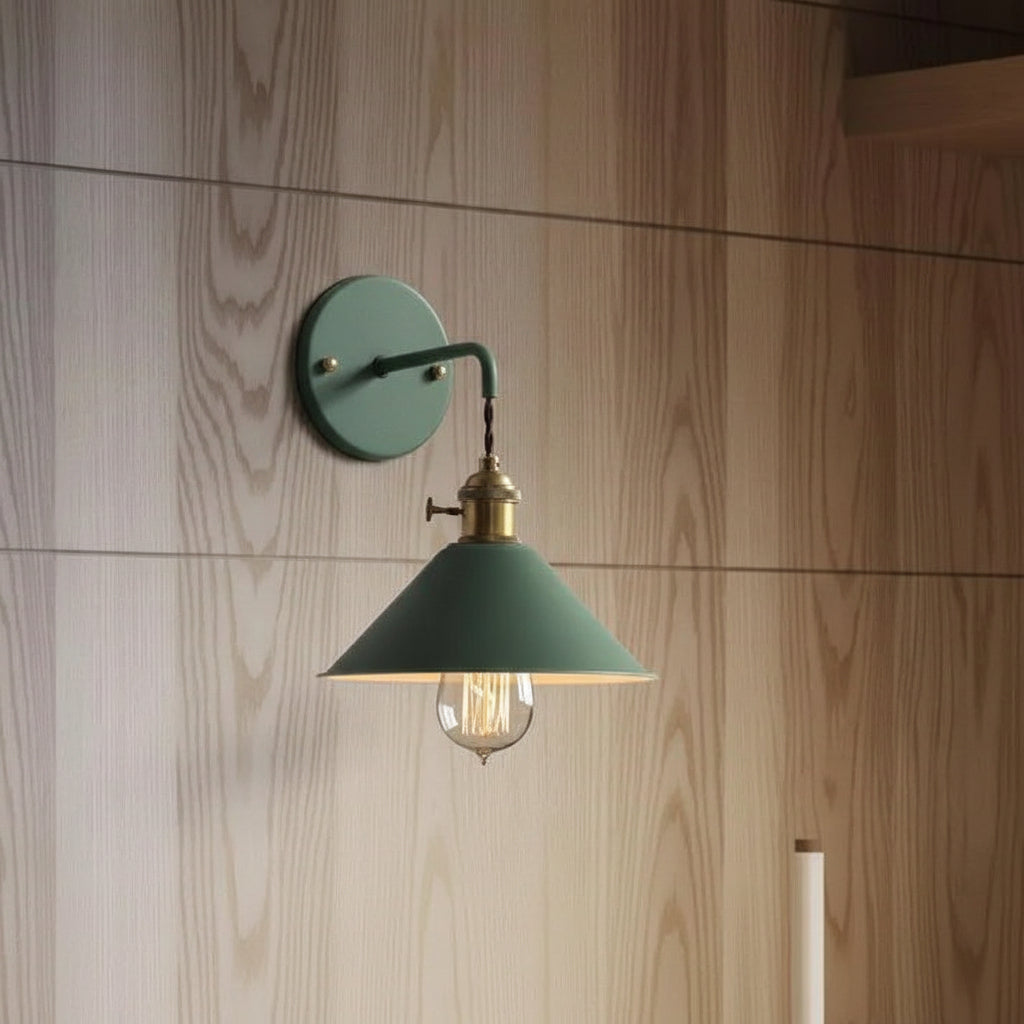 Green cone shade sconce lit against a timber panelled wall