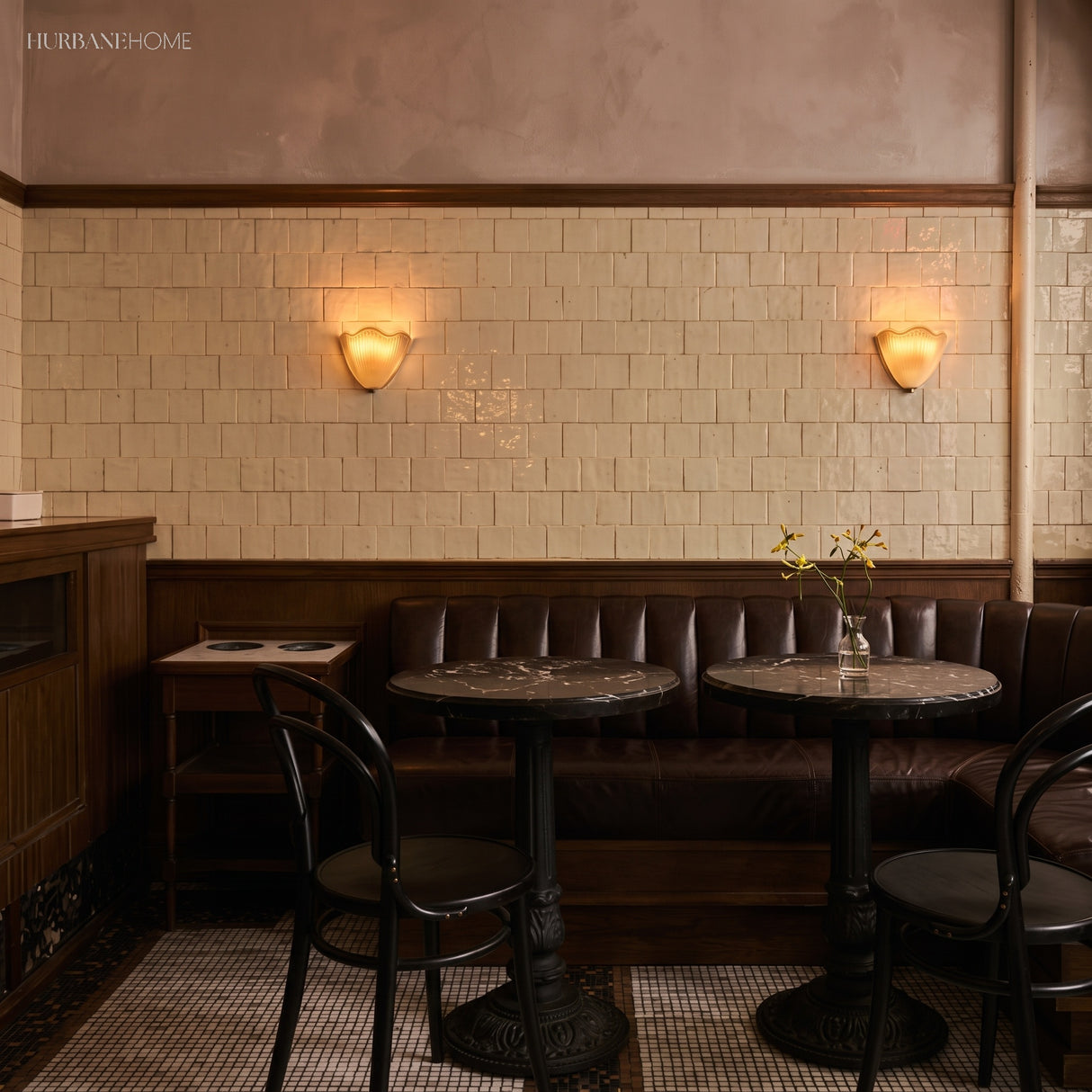 Pair of frosted glass wall sconces above banquette seating in a tiled cafe