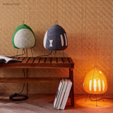 Rice paper table lamps in green, navy and orange on and beside a timber bench