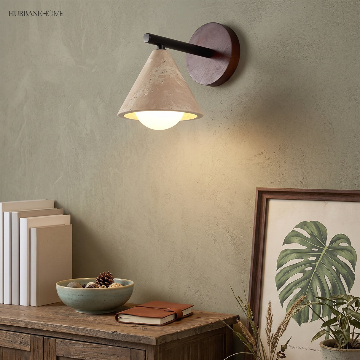 Wabi-sabi wall sconce glowing above a sideboard with books