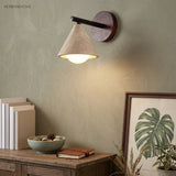 Wabi-sabi wall sconce glowing above a sideboard with books