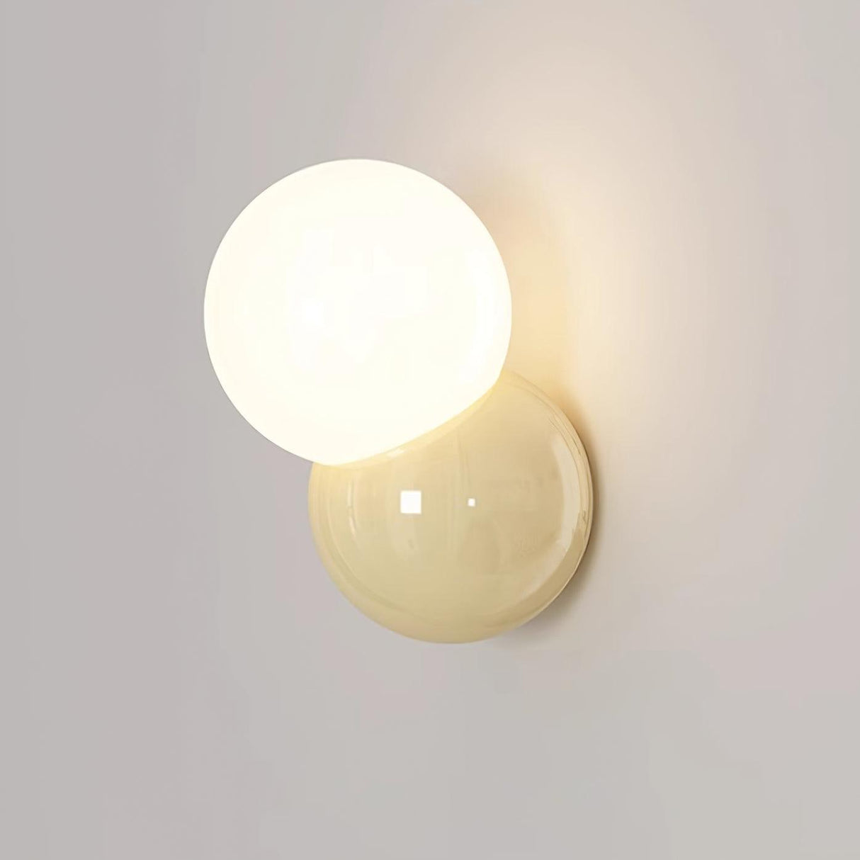 Close view of the lit opal globe overlapping the cream backplate on a wall
