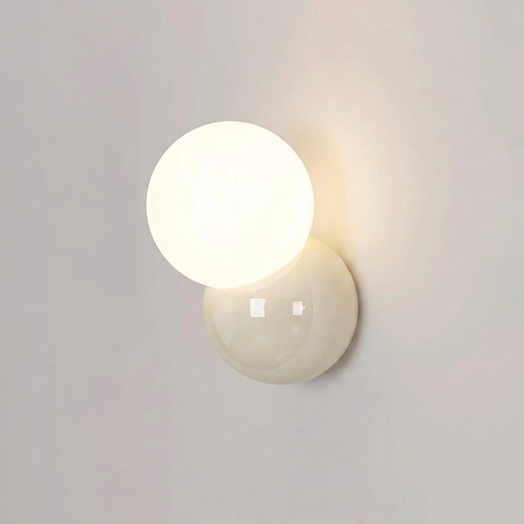 Wall sconce lit on a plain wall seen slightly from the side