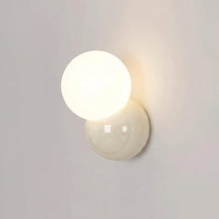 Wall sconce lit on a plain wall seen slightly from the side