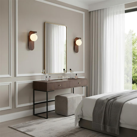 Wall sconce three quarter view highlighting globe and wood finish