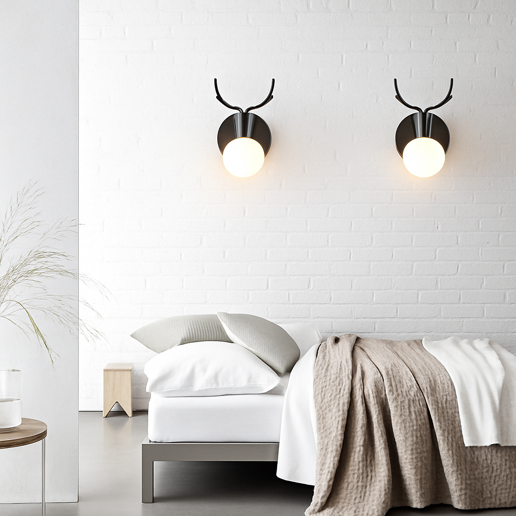 Two black antler sconces lit on a white brick bedroom wall