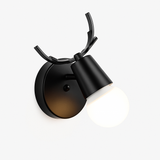 Black antler sconce with a metal shade and exposed round bulb