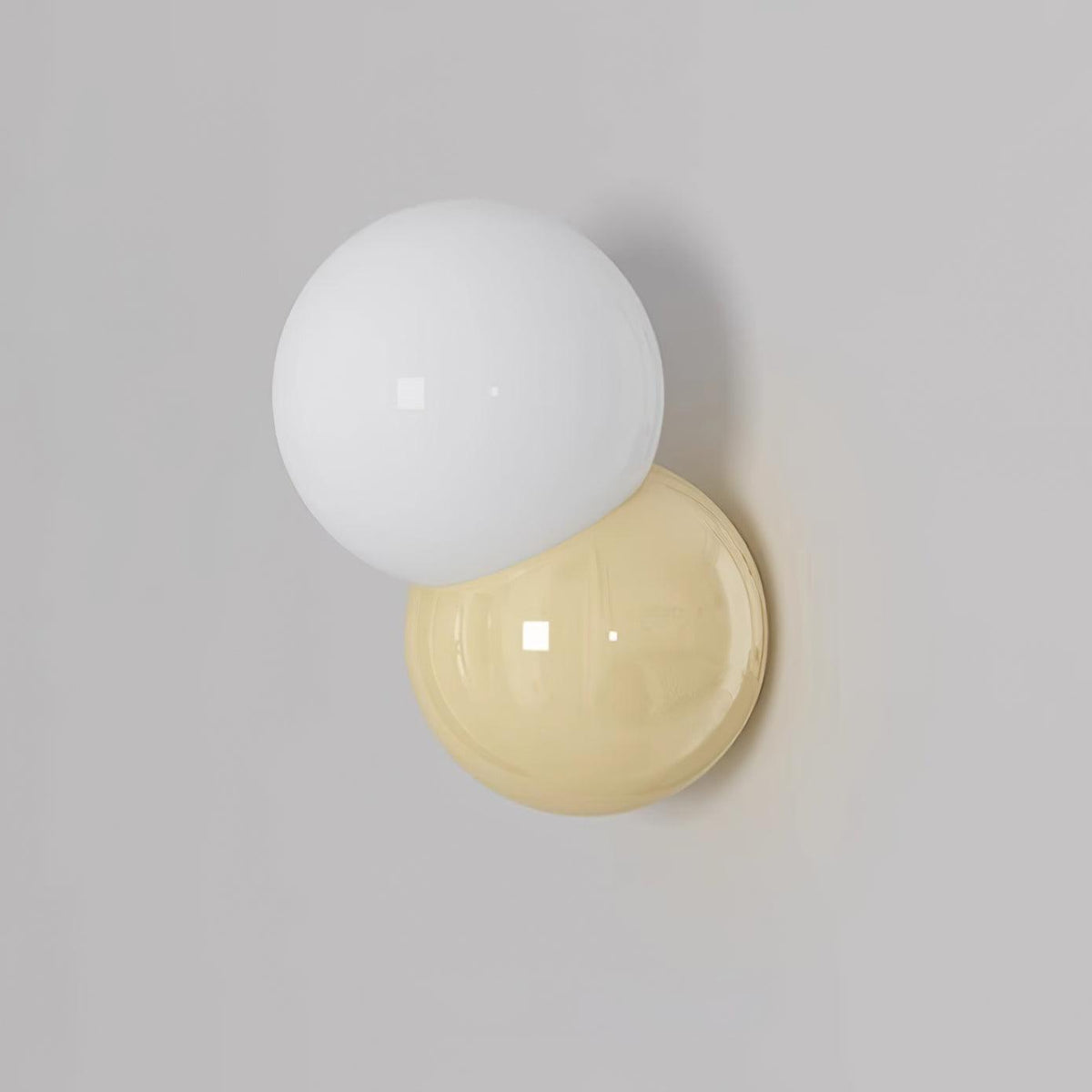 White opal globe overlapping a cream backplate, unlit against a grey wall