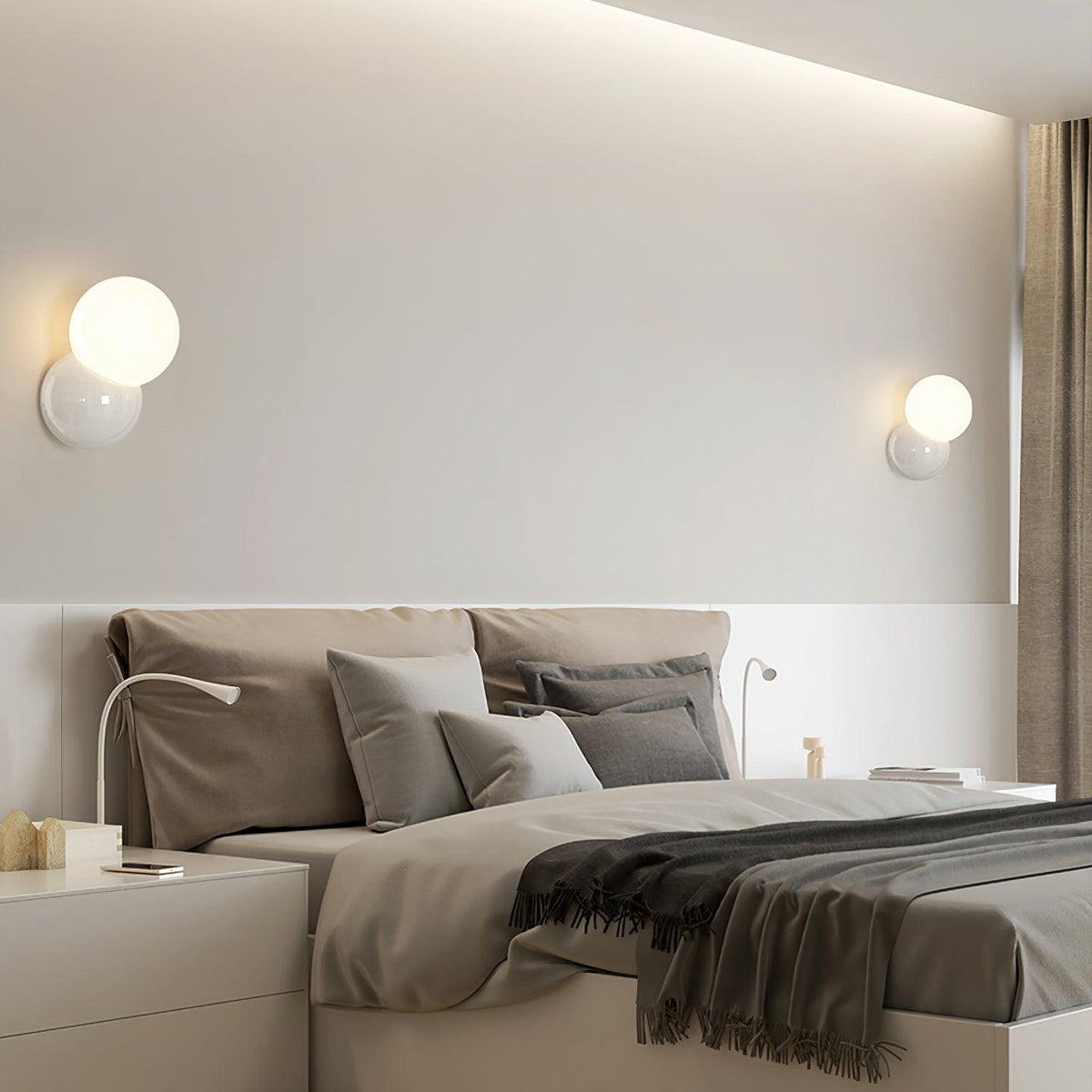 Wall sconces on either side of a low bed beneath a lit ceiling cove