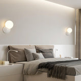 Wall sconces on either side of a low bed beneath a lit ceiling cove
