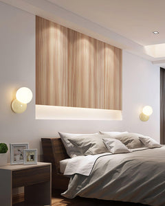 Pair of wall sconces flanking a timber panelled headboard wall in a bedroom