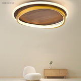 Round walnut grain flush mount light above a living room seating area