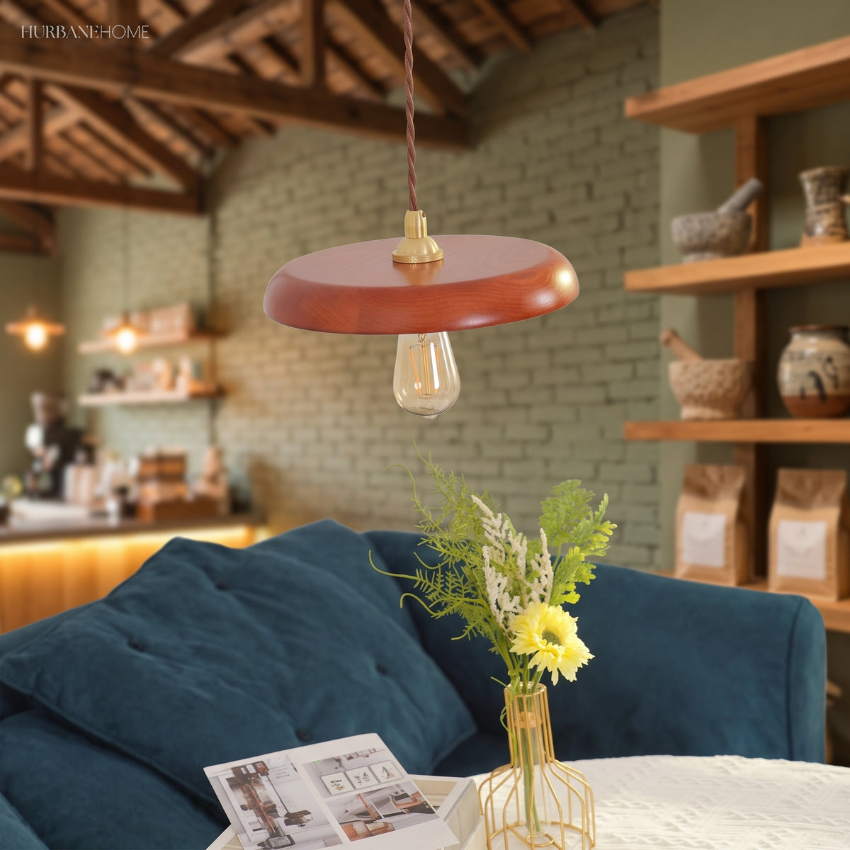 Walnut pendant light hung low beside a deep blue sofa in a barn style room