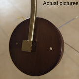 Close-up of round walnut wood backplate with brass square mount