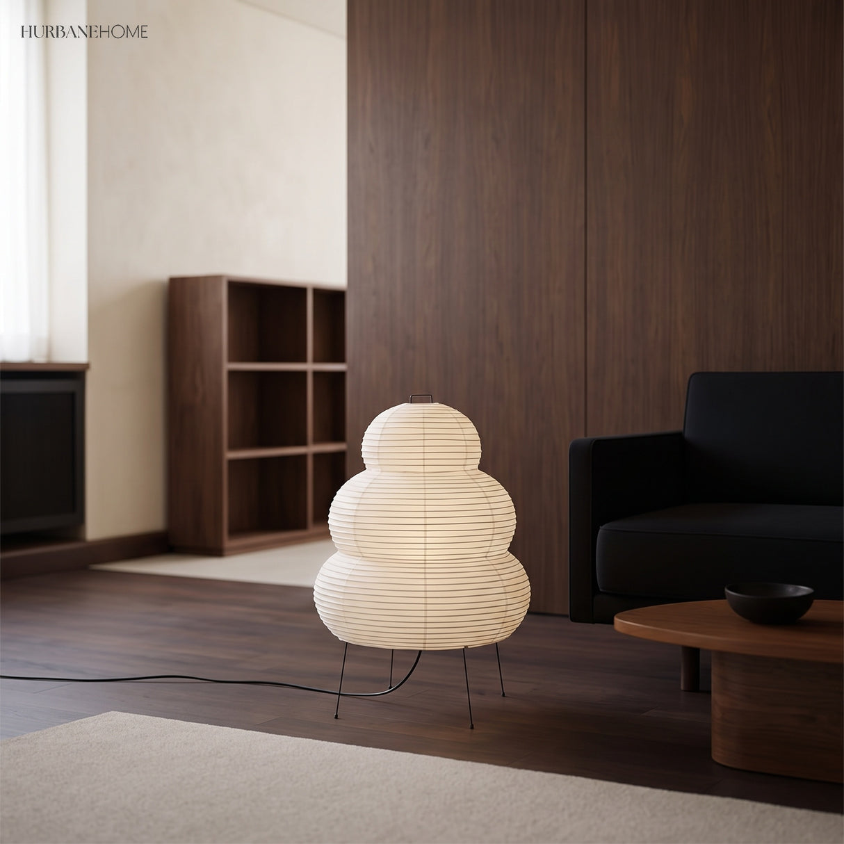 Rice paper floor lamp in a living room beside a dark sofa and timber joinery