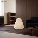 Rice paper floor lamp in a living room beside a dark sofa and timber joinery