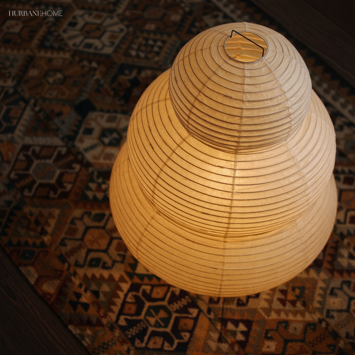 Close view of the lit rice paper shade on a patterned rug