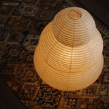 Close view of the lit rice paper shade on a patterned rug