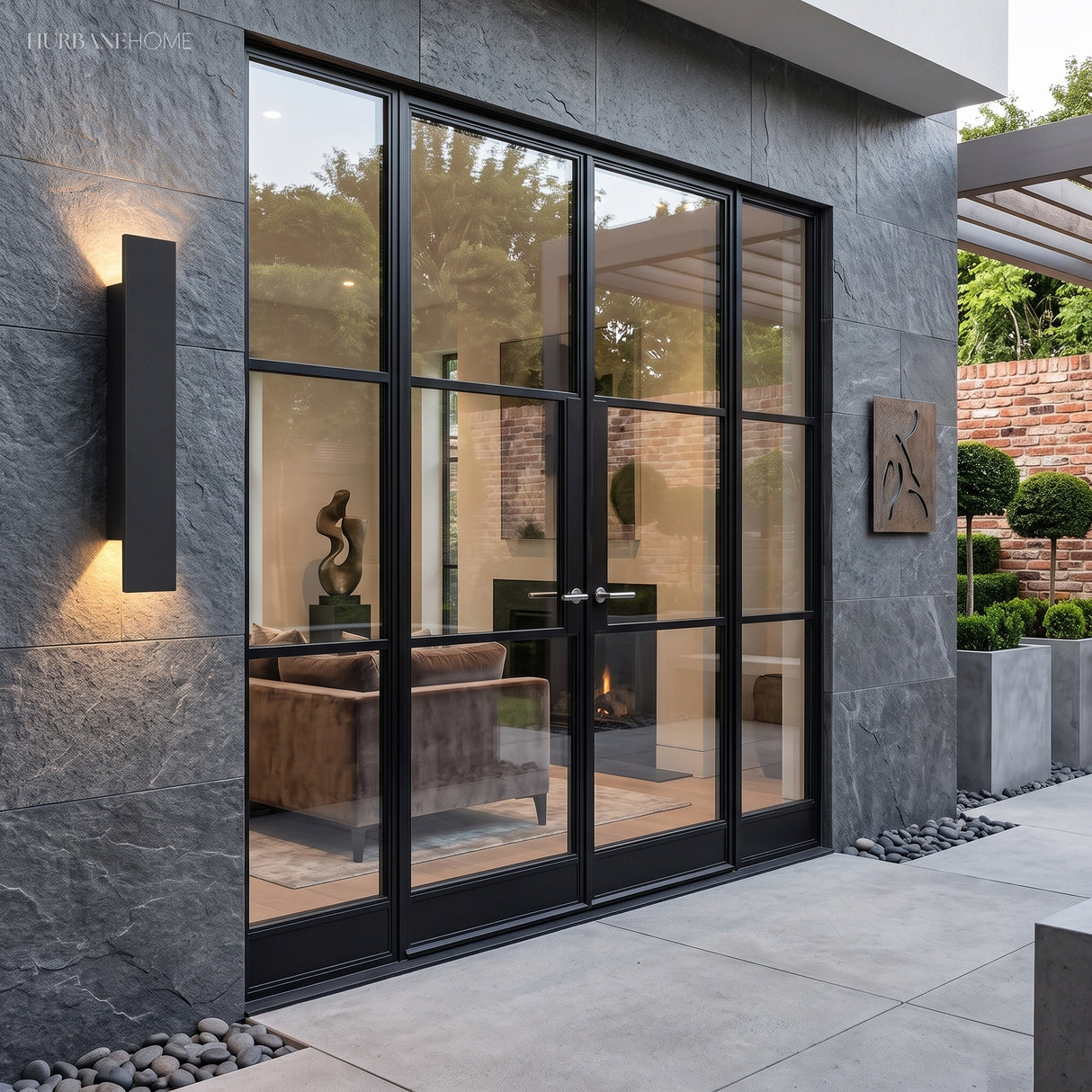 Black waterproof outdoor wall light beside black-framed glass doors on stone wall