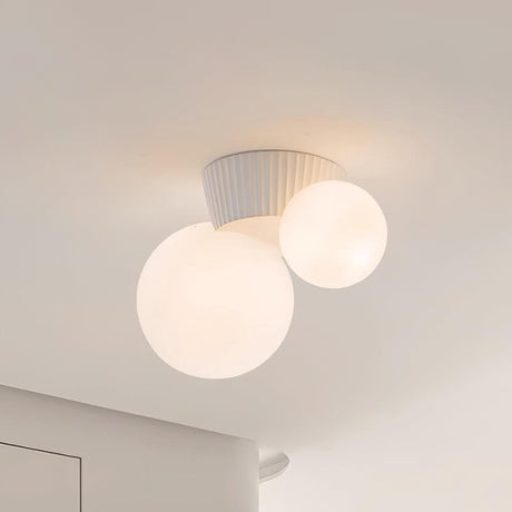 Close view of the white fluted canopy holding the two lit opal globes