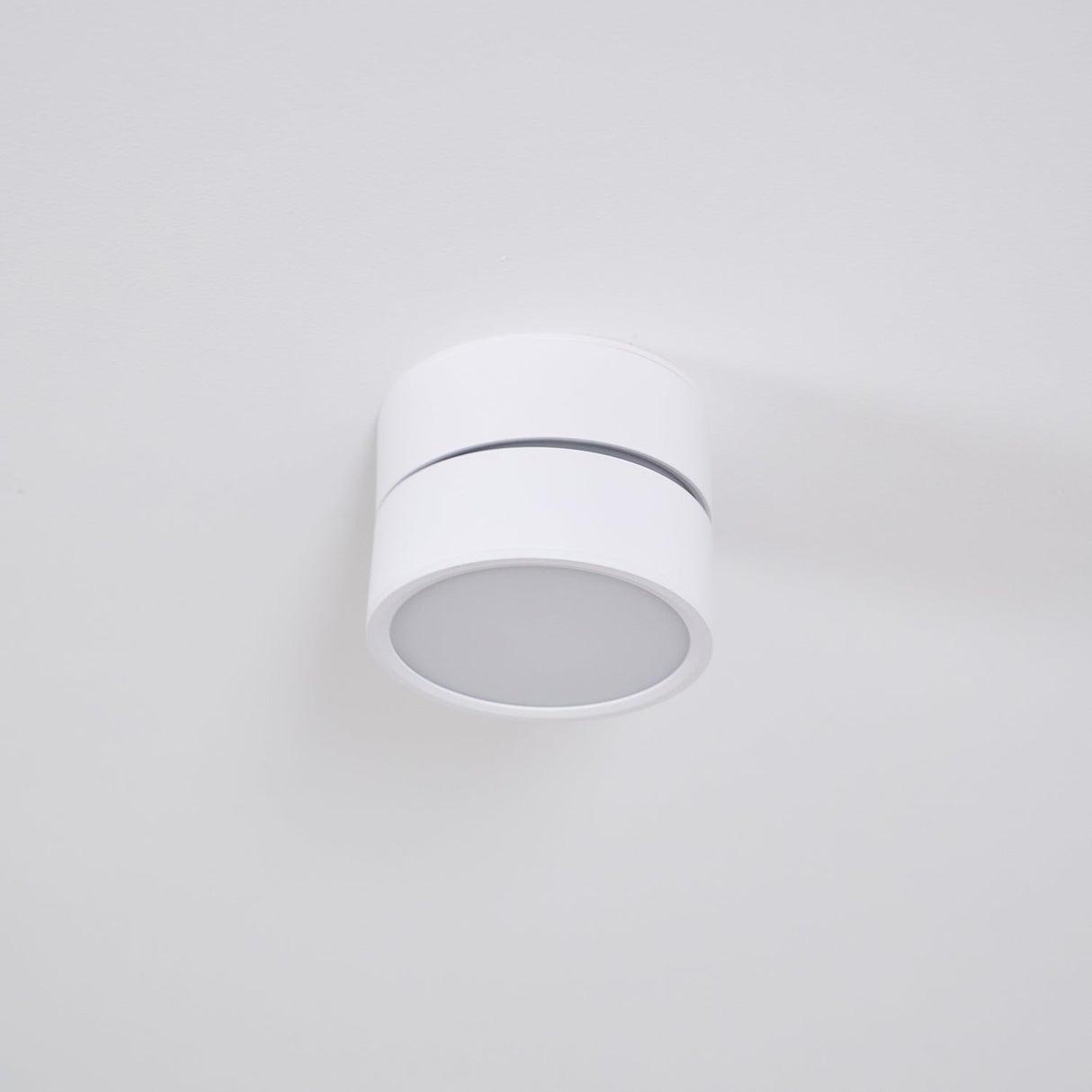 White spot light sitting flat against a plain ceiling with the head upright