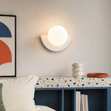White half moon wall sconce with a clean frosted glass globe shade