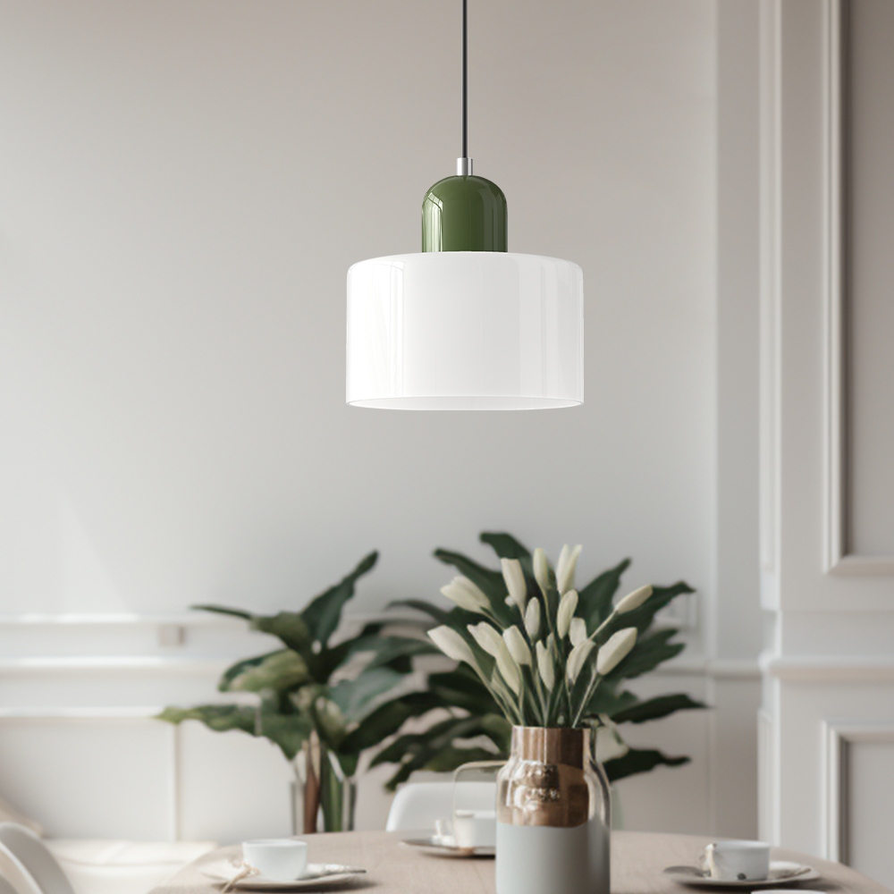 White glass pendant light with a green base above a dining table