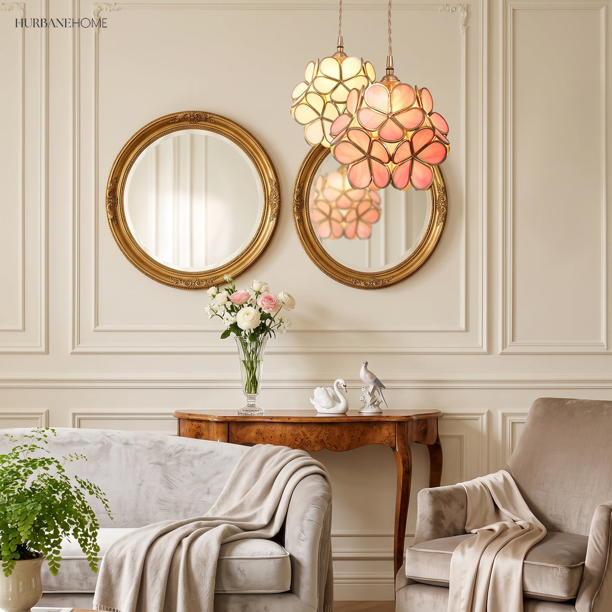 White and pink floral pendant lights beside a gilt mirror in an elegant lounge