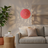 Pink woven globe pendant on a white cord