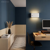 White wall-mounted sensor light above a home office desk